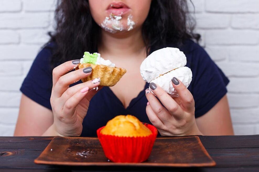 ženska s prekomerno telesno težo, ki jedo sladkarije